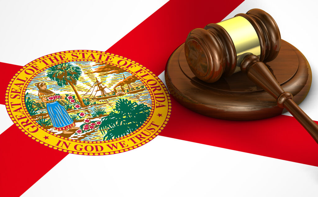 Florida US state law code legal system and justice concept with a 3d render of a gavel on the Floridan flag on background.