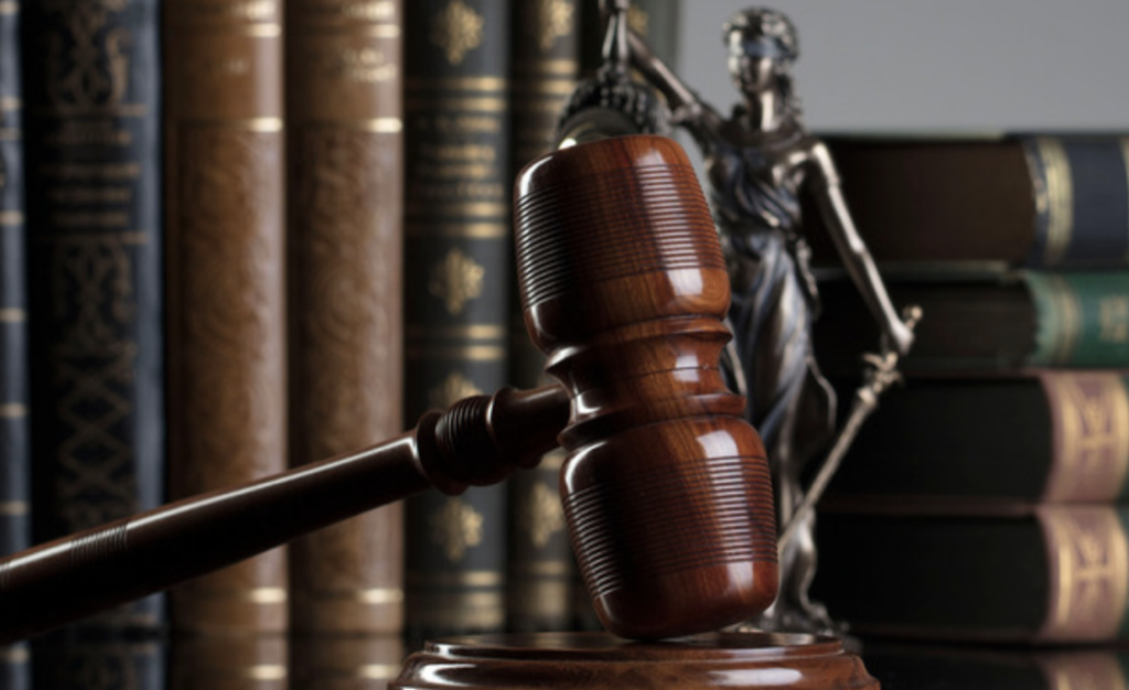 judge gavel hammer in front of any justice and books, in a law setting